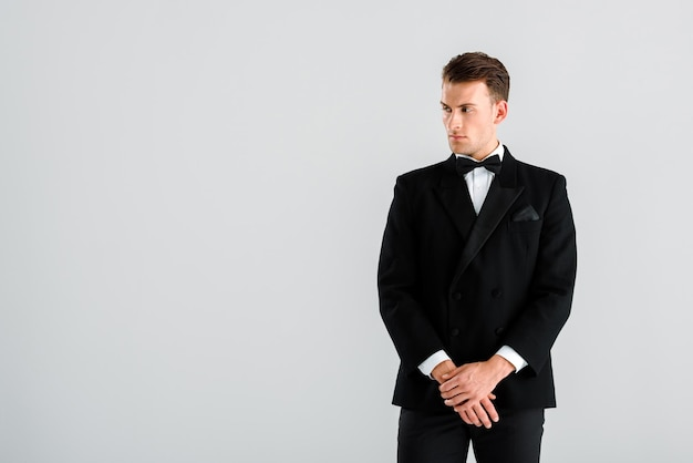 rich-man-black-suit-gesturing-while-standing-isolated-grey_824701-13629